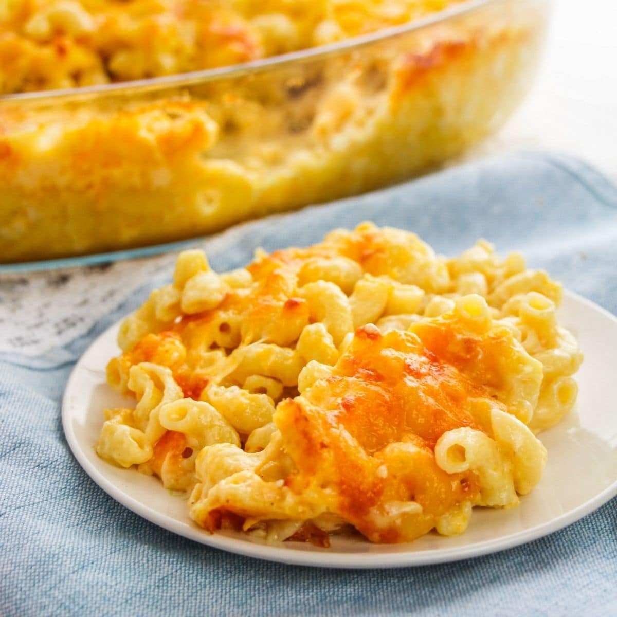 Golden baked macaroni and cheese with a crispy breadcrumb crust and melted cheddar cheese in a ceramic dish